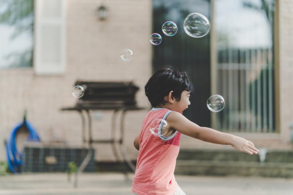A child blowing bubbles outdoors