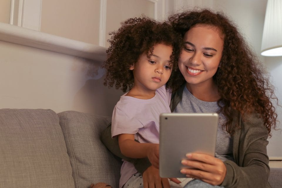 A mother and daughter looking at a tablet together