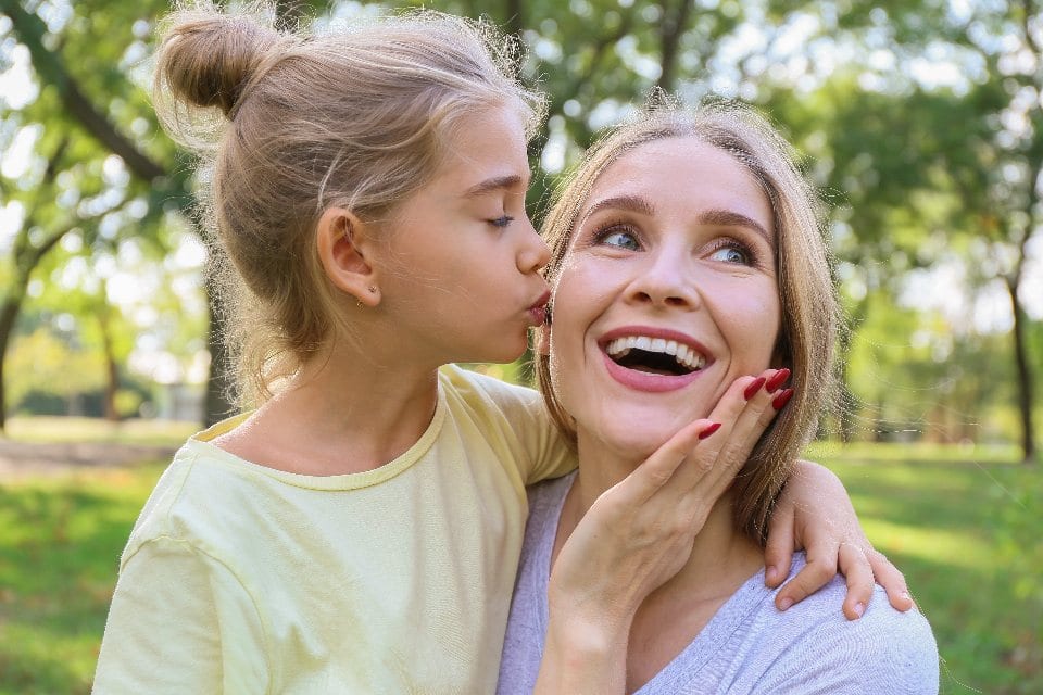 A daughter kissing her mother on the cheek
