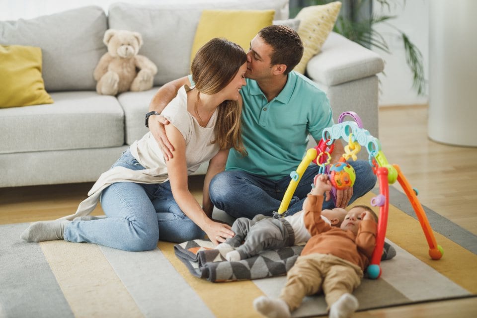 A family playing together on the living room floor